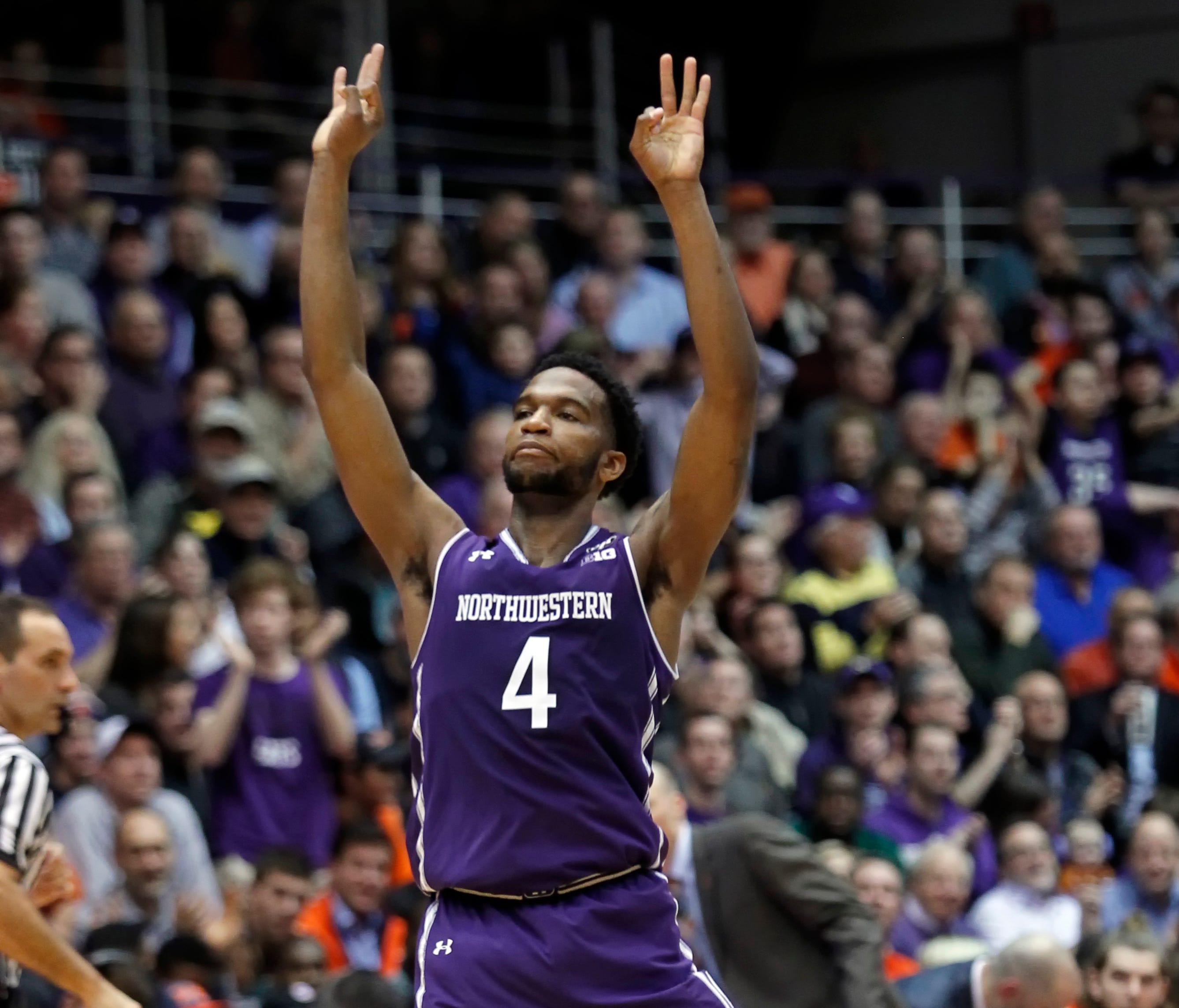 Northwestern Wildcats forward Vic Law signals three.