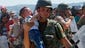 A Macedonian policeman carries a child across the border