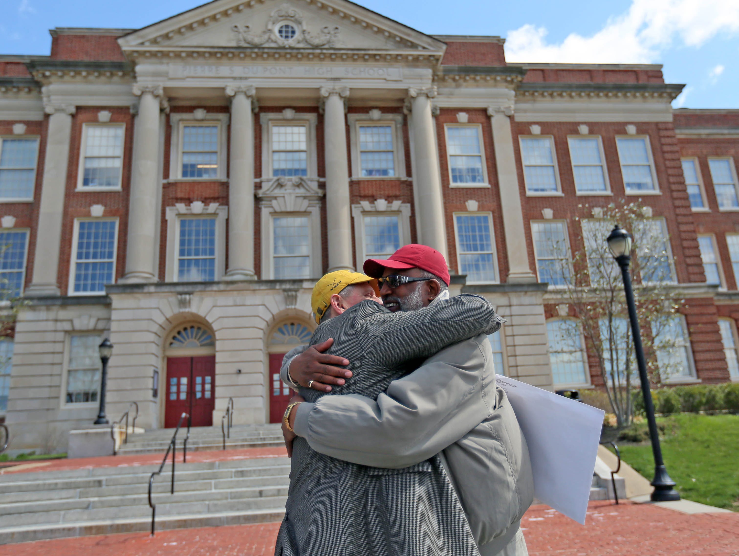Randy Johnson gives a big hug to his former 1968 basketball teammate Ron Smith in front P.S. du Pont High School.