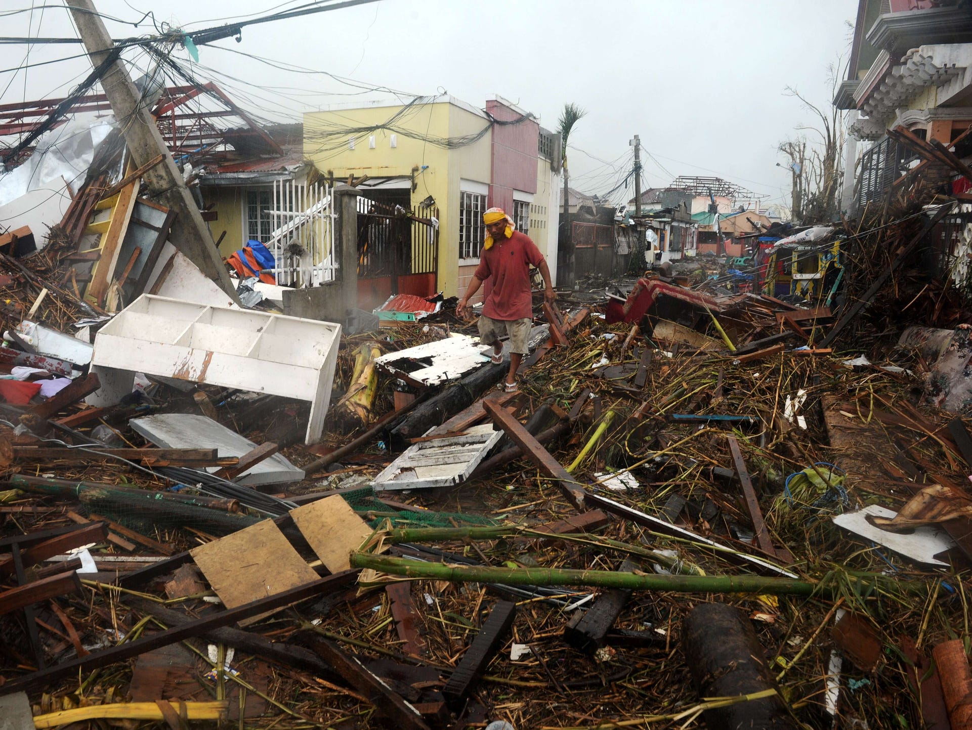 A man walks among debris of destroyed houses in Tacloban.