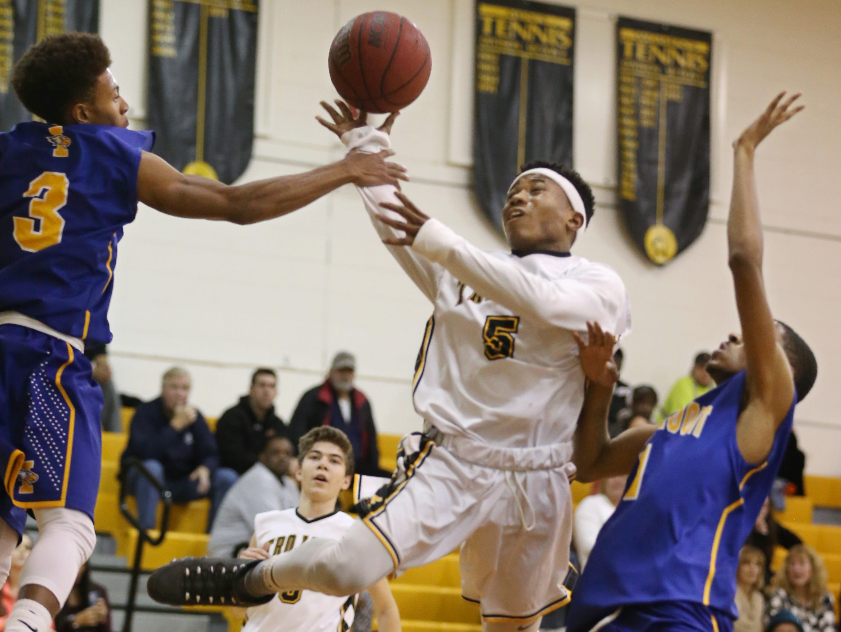 Greece Athena's Kenny Speed, center, draws a foul from Irondequoit's Ty'Reek Sizer, left, as he drives the lane in the first half during their game Monday in Greece.
