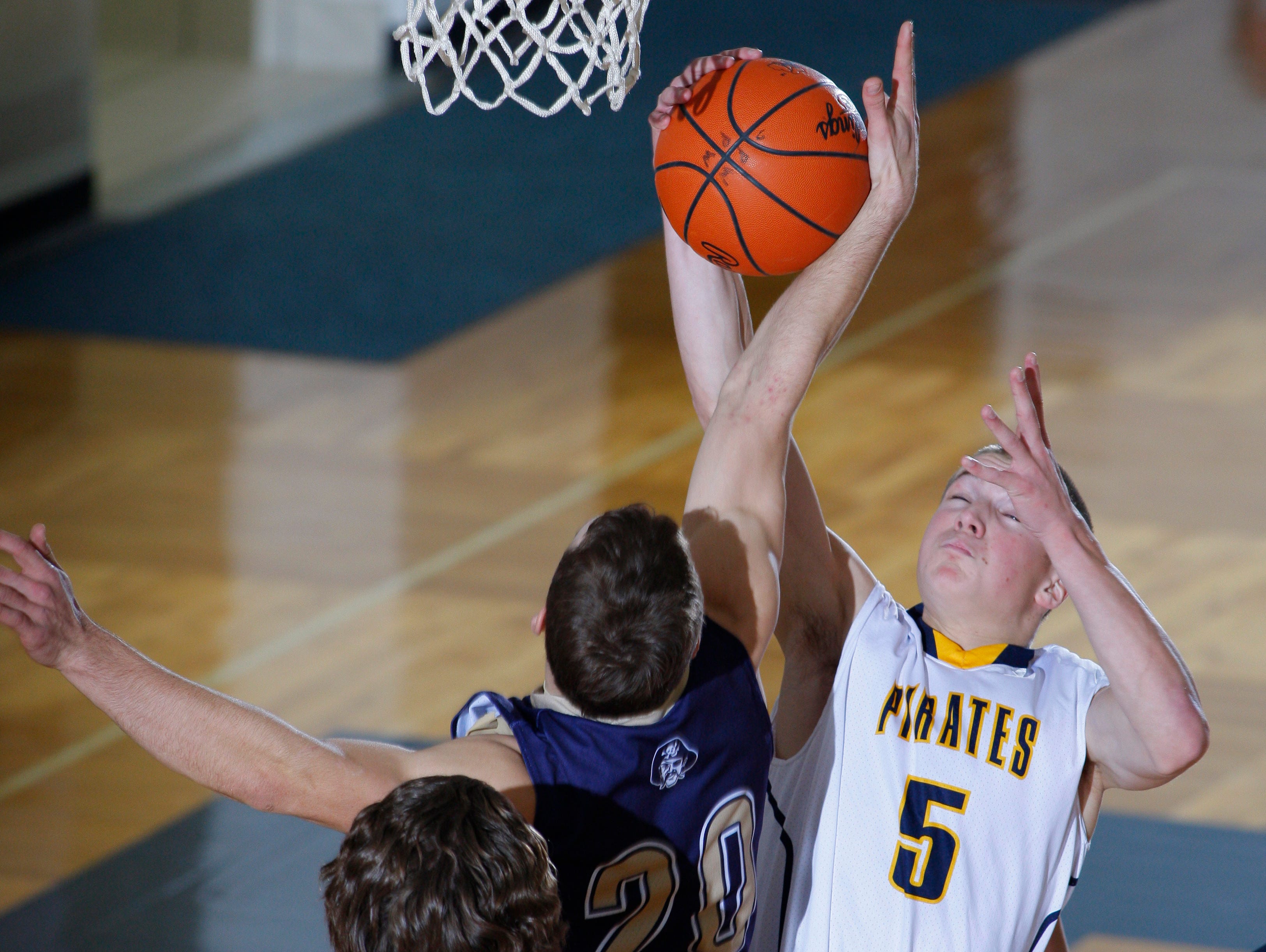 Pewamo-Westphalia's Logan Hengesbach (5) and Fulton's Colton Stipcak (20) vie for a rebound as P-W's Jimmy Lehman (52) watches Tuesday, Jan. 3, 2017, at Pewamo-Westphalia High School. P-W won 63-45.