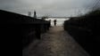 A woman with her child walks off Neptune Beach as heavy