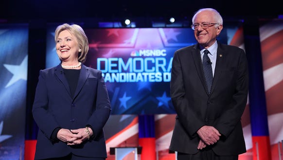 Hillary Clinton and Bernie Sanders stand on stage at