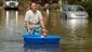 Laura Moravek carries her granddaughter, Alyssa Guarino, 21- months, in a kiddie pool as they walks through the flooded road of South Allen, just east of Stapley Drive in Mesa on Tuesday, September 9, 2014. Moravek and Alyssa live just down the street where their home sustained some minor flooding. This neighborhood east of Stapley Drive and north of the US60 sustained major flooding from yesterday's record rainfall.