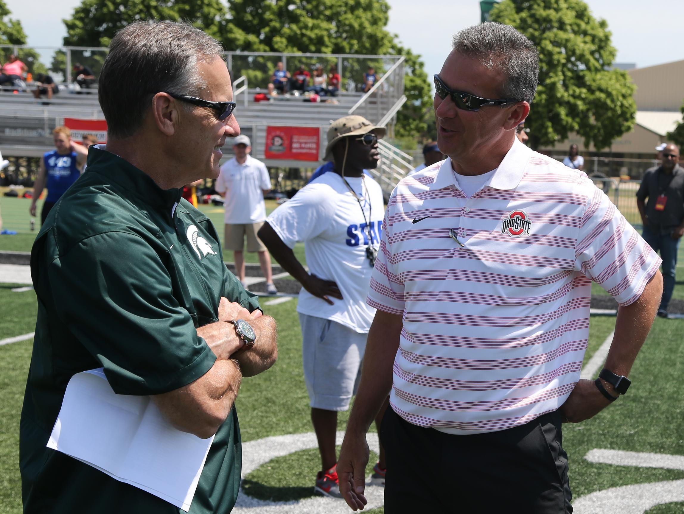 Michigan State coach Mark Dantonio, left, and Ohio State coach Urban Meyer talk Friday during the Sound Mind Sound Body camp at Wayne State.