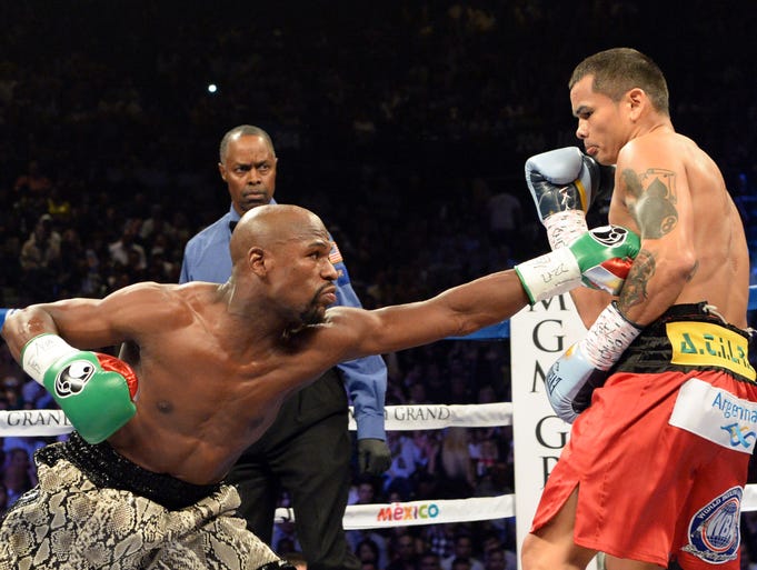 Mayweather reaches for Maidana in the early rounds.