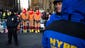 Spectators dressed as turkeys stand behind police barricades as they wait for the parade to begin.