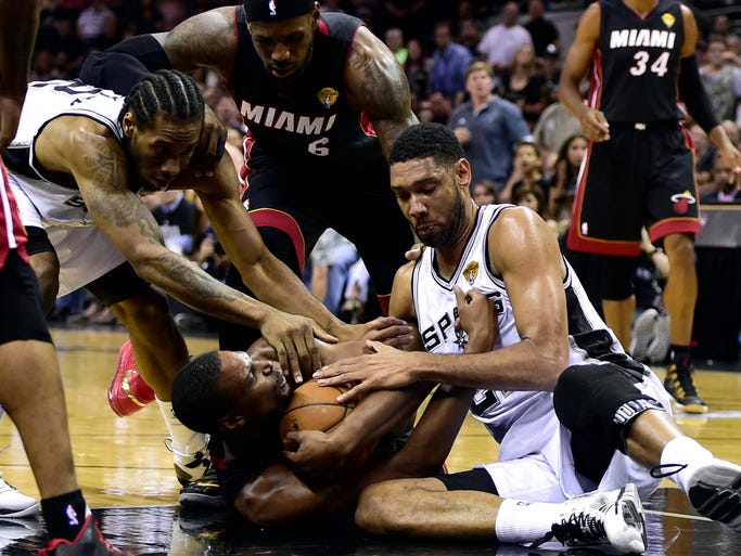 Game 5 in San Antonio: Spurs 104, Heat 87 -- Chris Bosh, center, corrals a loose ball during a first-half scramble against Kawhi Leonard, left, and Tim Duncan, right.