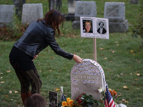 Jillian Paris places an "I Voted" sticker on the headstone