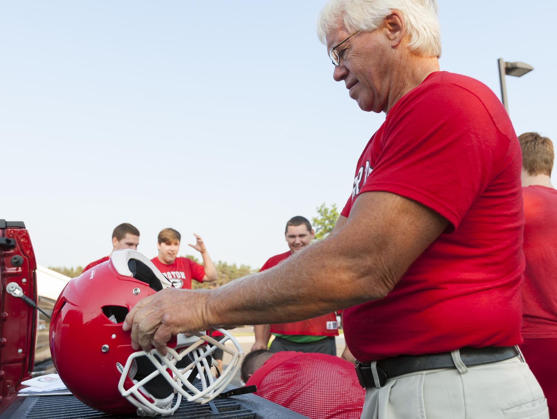 Tom Goddard, the new head football coach Groton High, adjusts a helmet shortly before 8 a.m. Monday on the first day of practice for high school sports.
