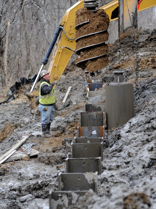 drilling of holes in which 48-foot H-pile structural beams will be inserted then filled with concrete Thursday as part of the $1.25 million slide repair project on Ohio 772