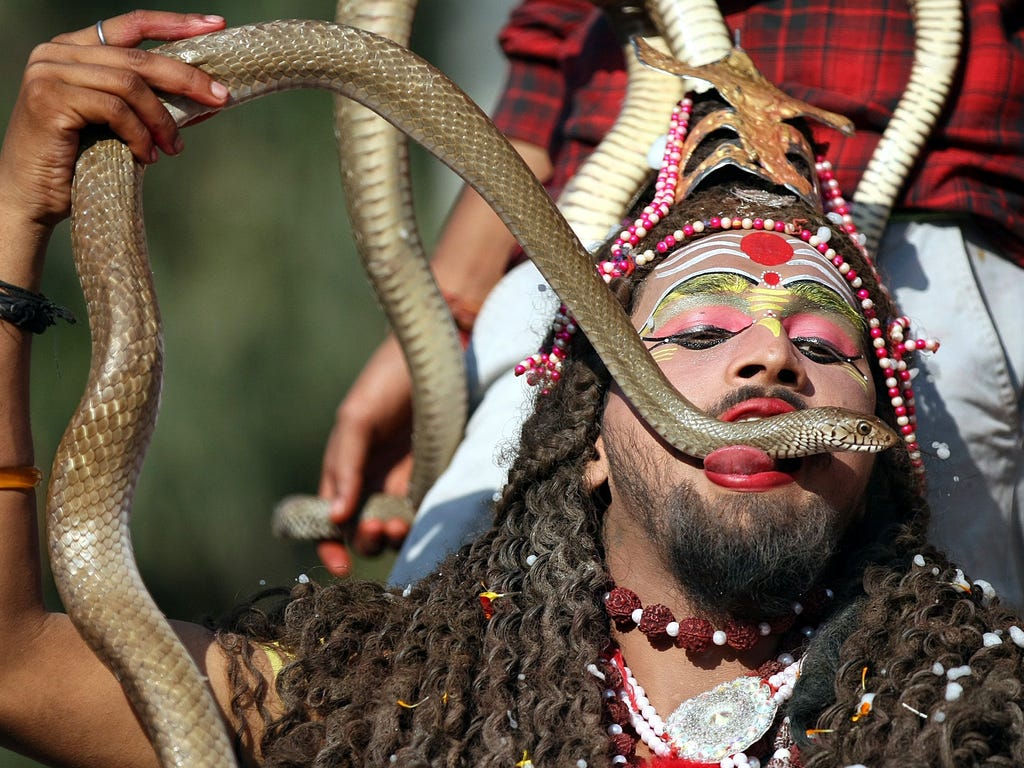 A man dressed as Lord Shiva performs with live snakes as he takes part in the Maha Shivratri festival in Jammu,  India. Maha Shivratri, the night of the worship of Shiva, is celebrated on the 14th night of the new moon during the dark half of the mon