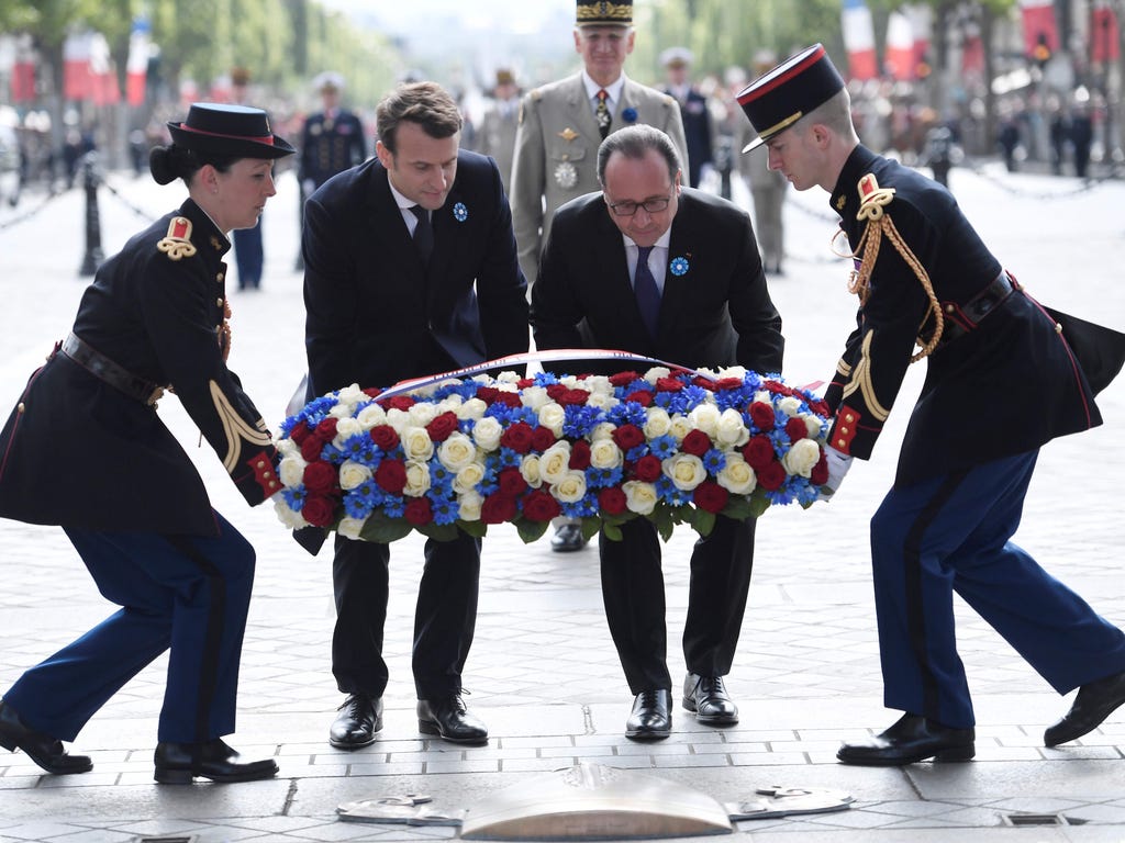 Outgoing French president Francois Hollande (R) and French president-elect Emmanuel Macron (L) lay a wreath of flowers during the ceremony marking the 72nd anniversary of the victory over Nazi Germany during WWII on May 8, 1945 under the Arc de Triom