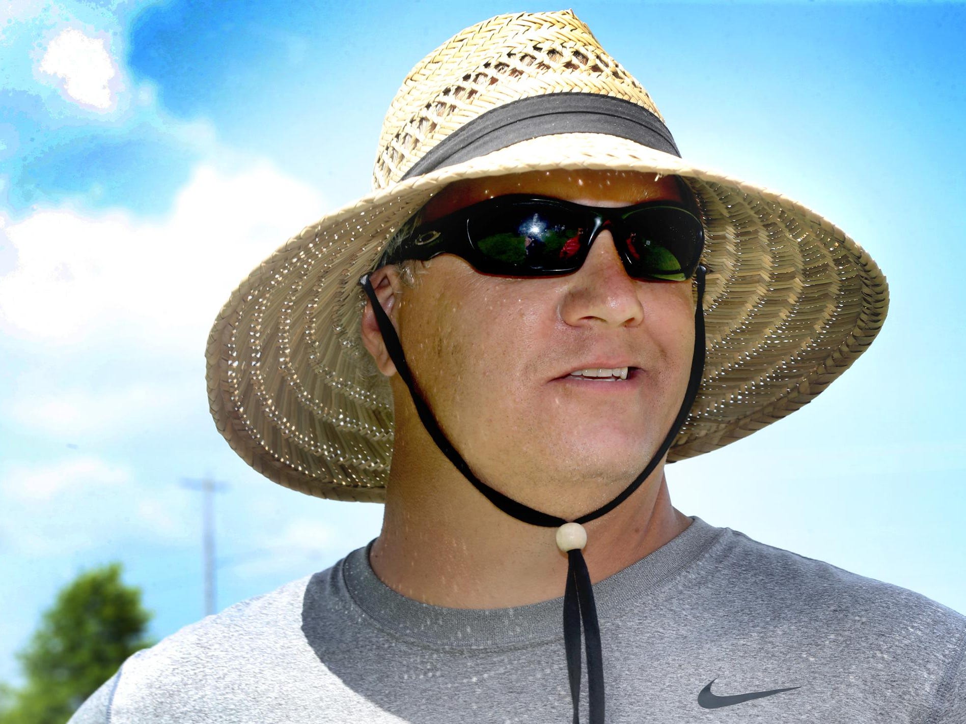 David Watson, the new head coach of the Blackman High School football team, tries to stay cool and out of the sun under his big straw hat as the Blackman Blaze competes in the 7-on-7 Bojangles Passing Tournament on Thursday, July 9 at Riverdale High School in Murfreesboro.