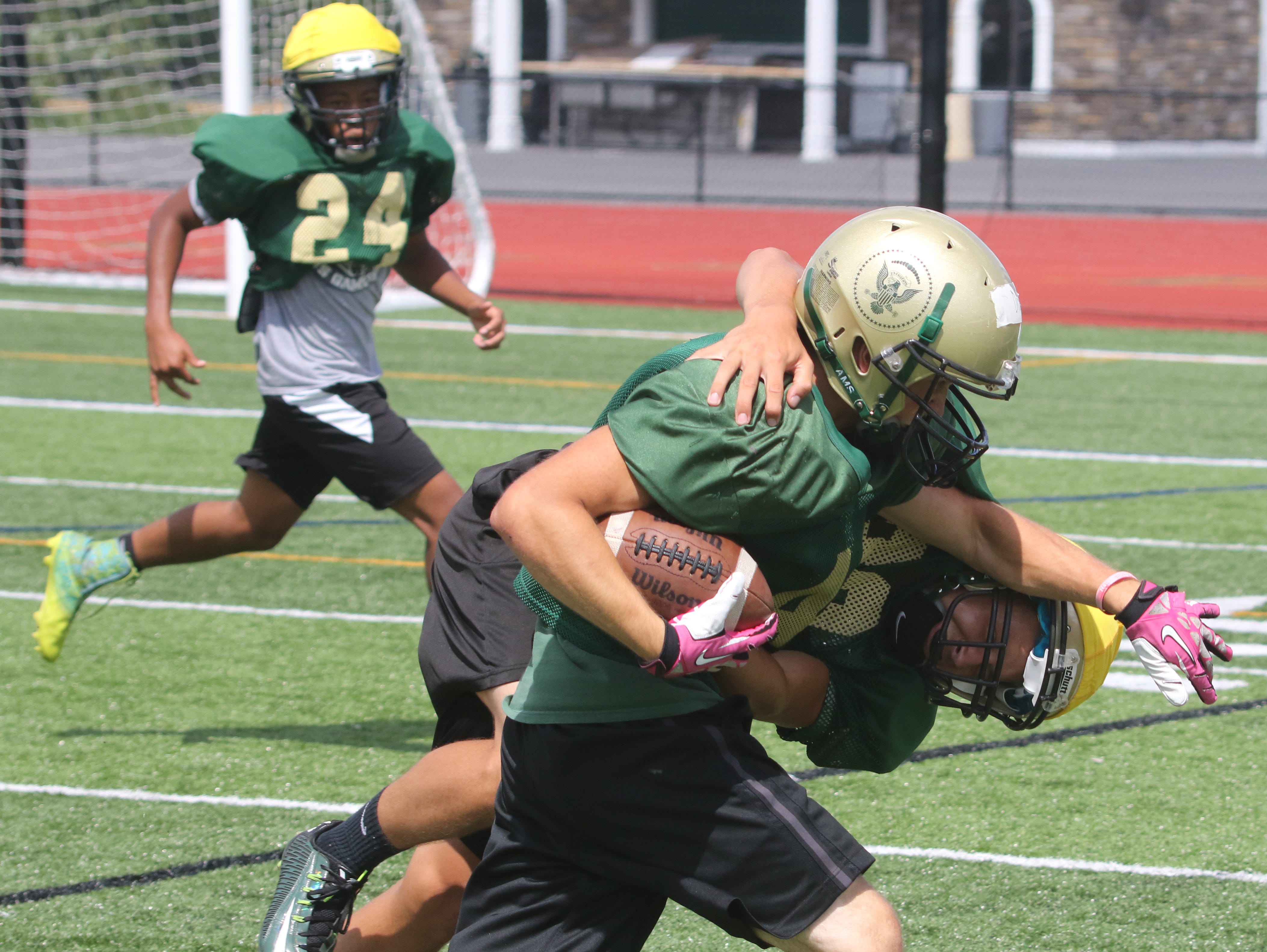 A pair of Franklin D. Roosevelt High School football players get tangled during a preseason practice.