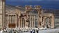 Syrian citizens walk in the ancient city of Palmyra