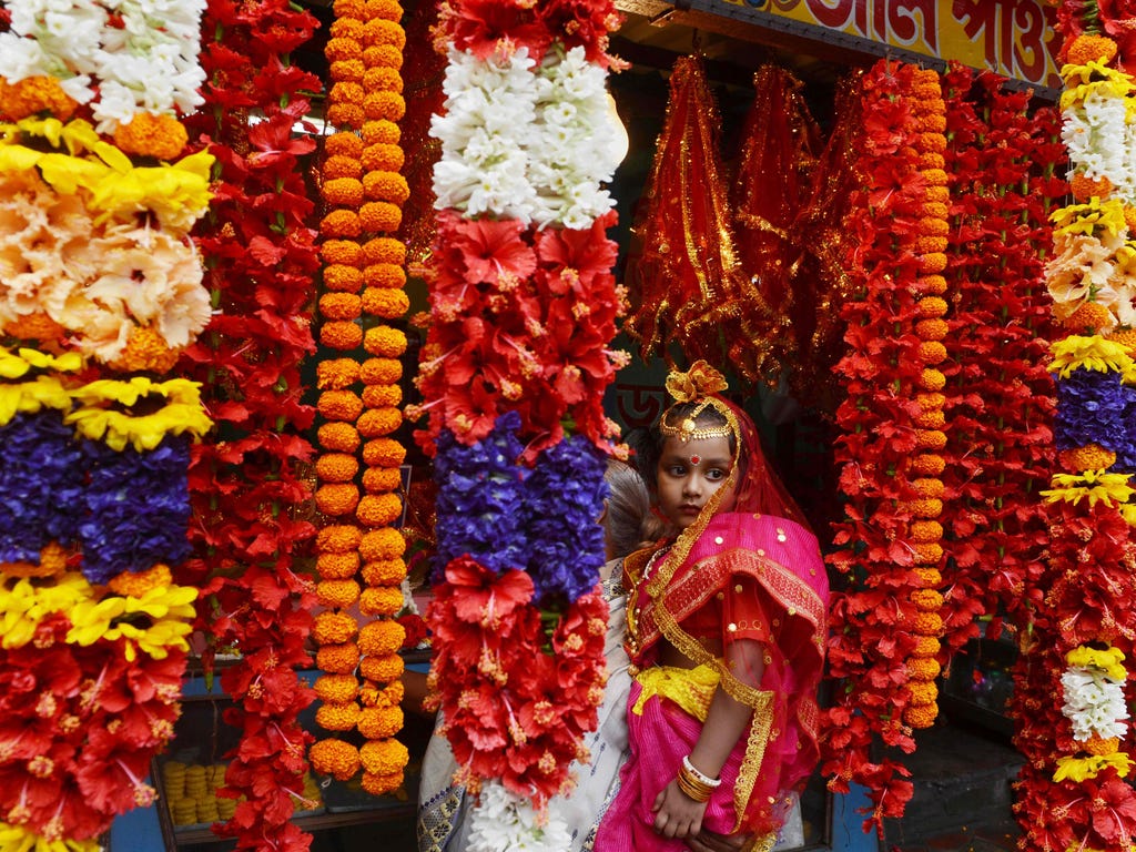 A girl arrives to take part in Kumari Puja at the Adyapeath Ashram on the outskirts of Kolkata, India. Kumari Puja, the tradition of honoring young girls as manifestations of the divine female energy, is a part of the annual Hindu festival Ram Navami