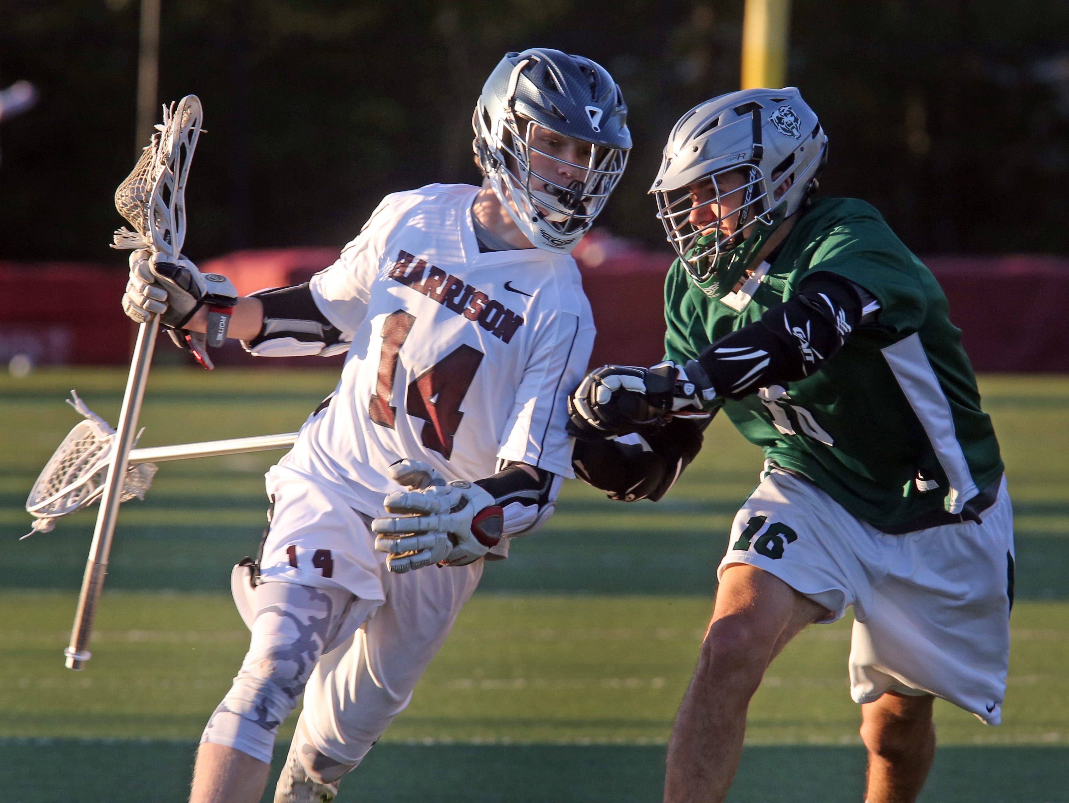 Brewster's Martin Saijanin (16) guards Harrison's Matt McLaughlin (14) during boys lacrosse Section 1 Class B playoff game at Harrison High School on May 16, 2016.