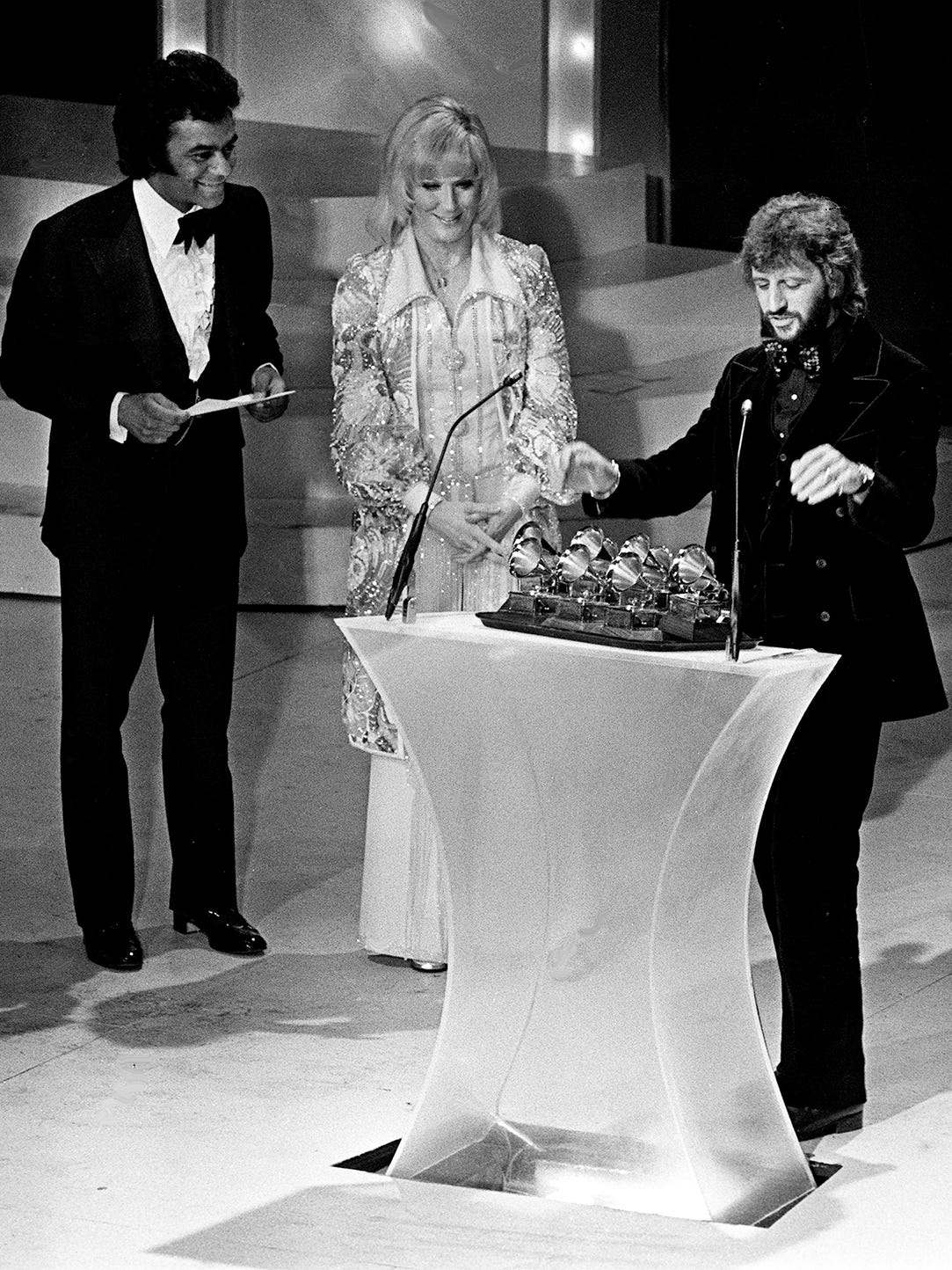 Ringo Starr, right, reaches for the platter of awards