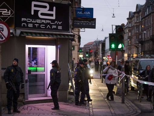 Armed police stand guard outside an Internet cafe that