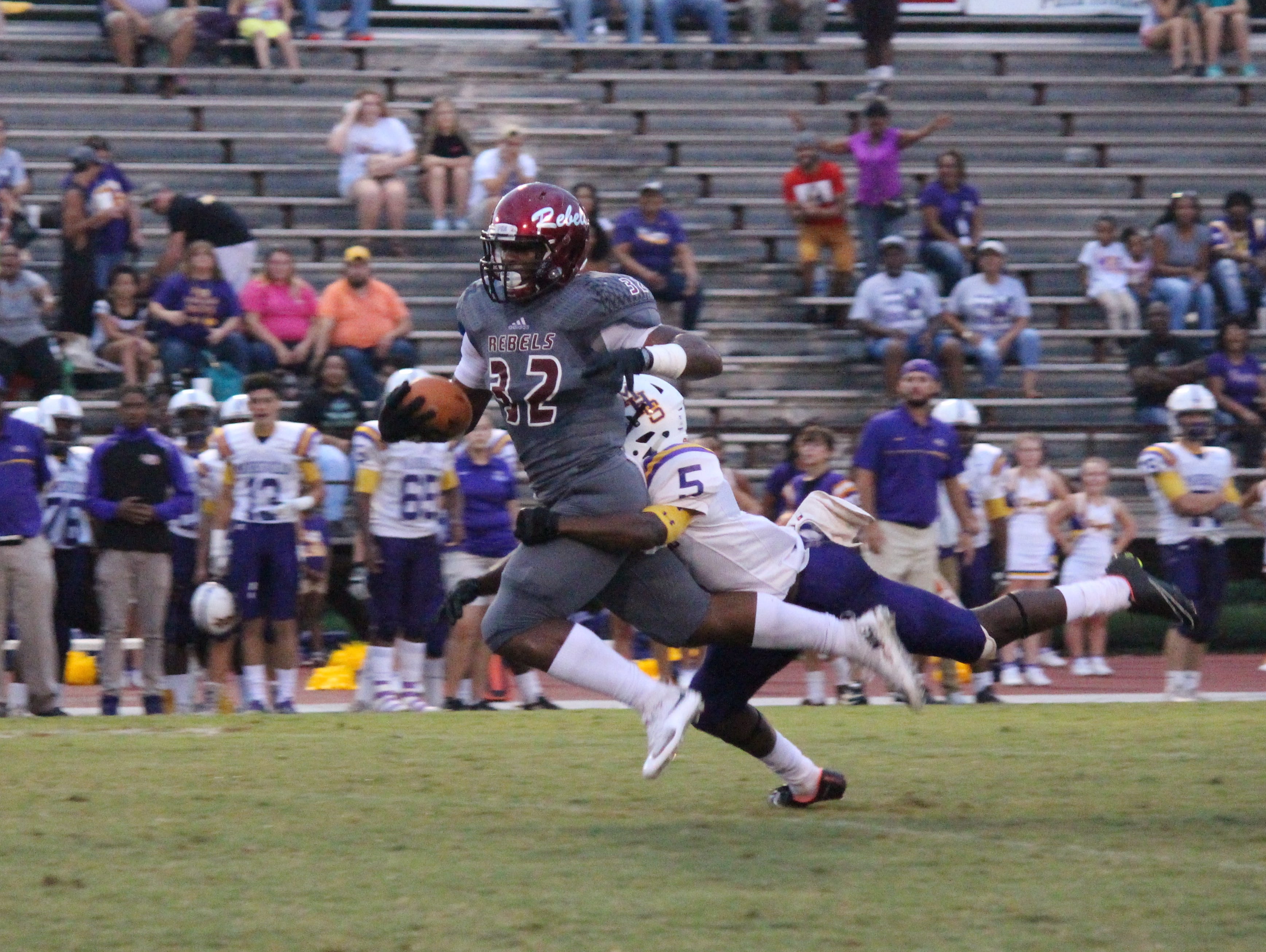 Pineville senior Landon King (32, left) tries to break a tackle from Marksville's Ze Ballard.