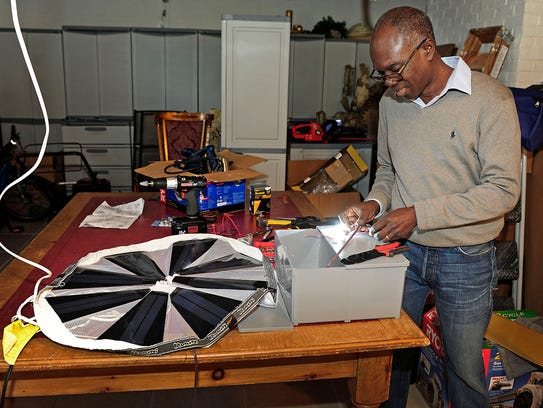 Mawuli Tse works on a portable solar unit at his workshop