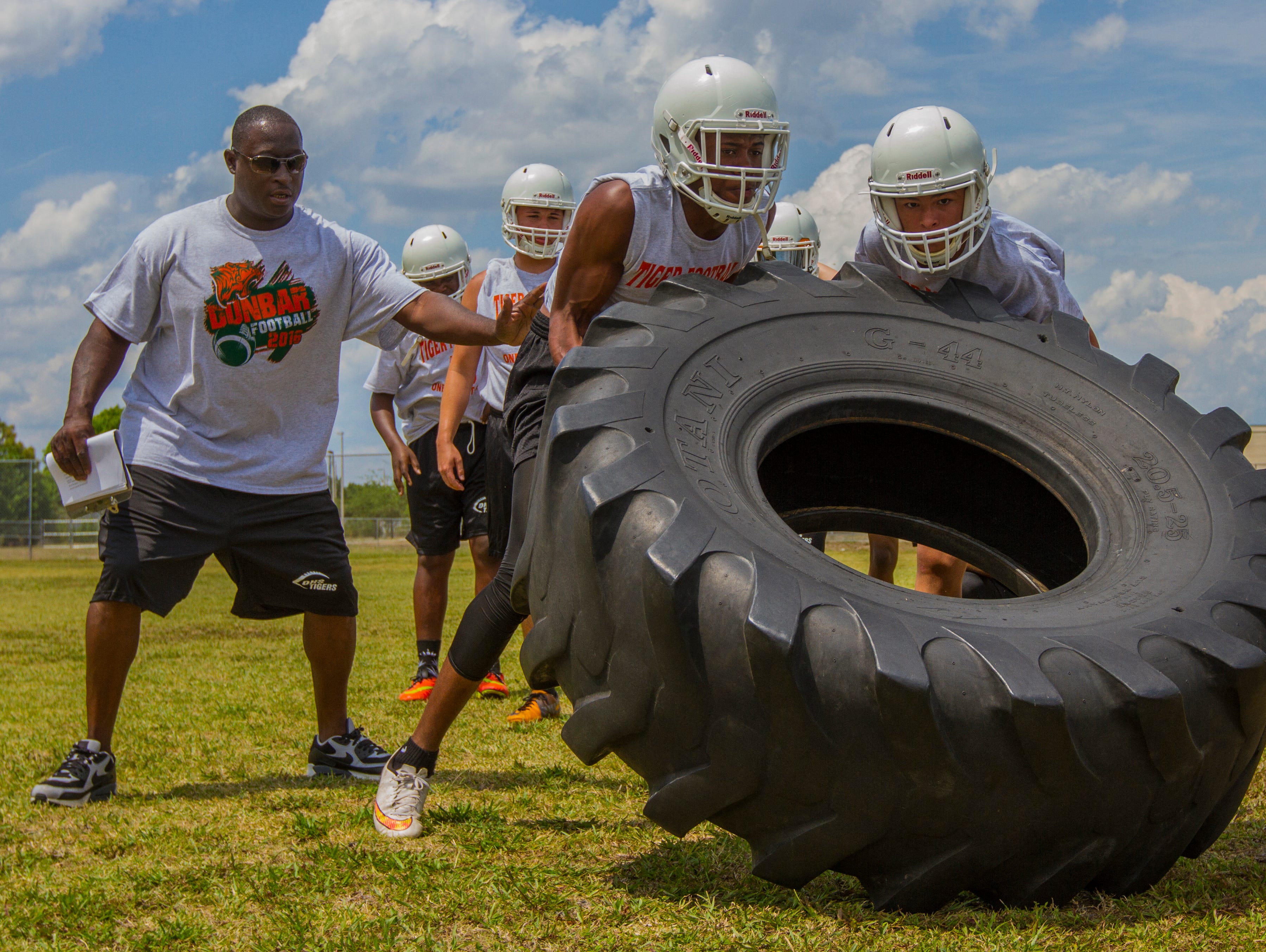 Dunbar High School's interim football coach Sammy Brown works on strength and conditioning drills with his players during an after school practice Monday (4/25/16) in Fort Myers.
