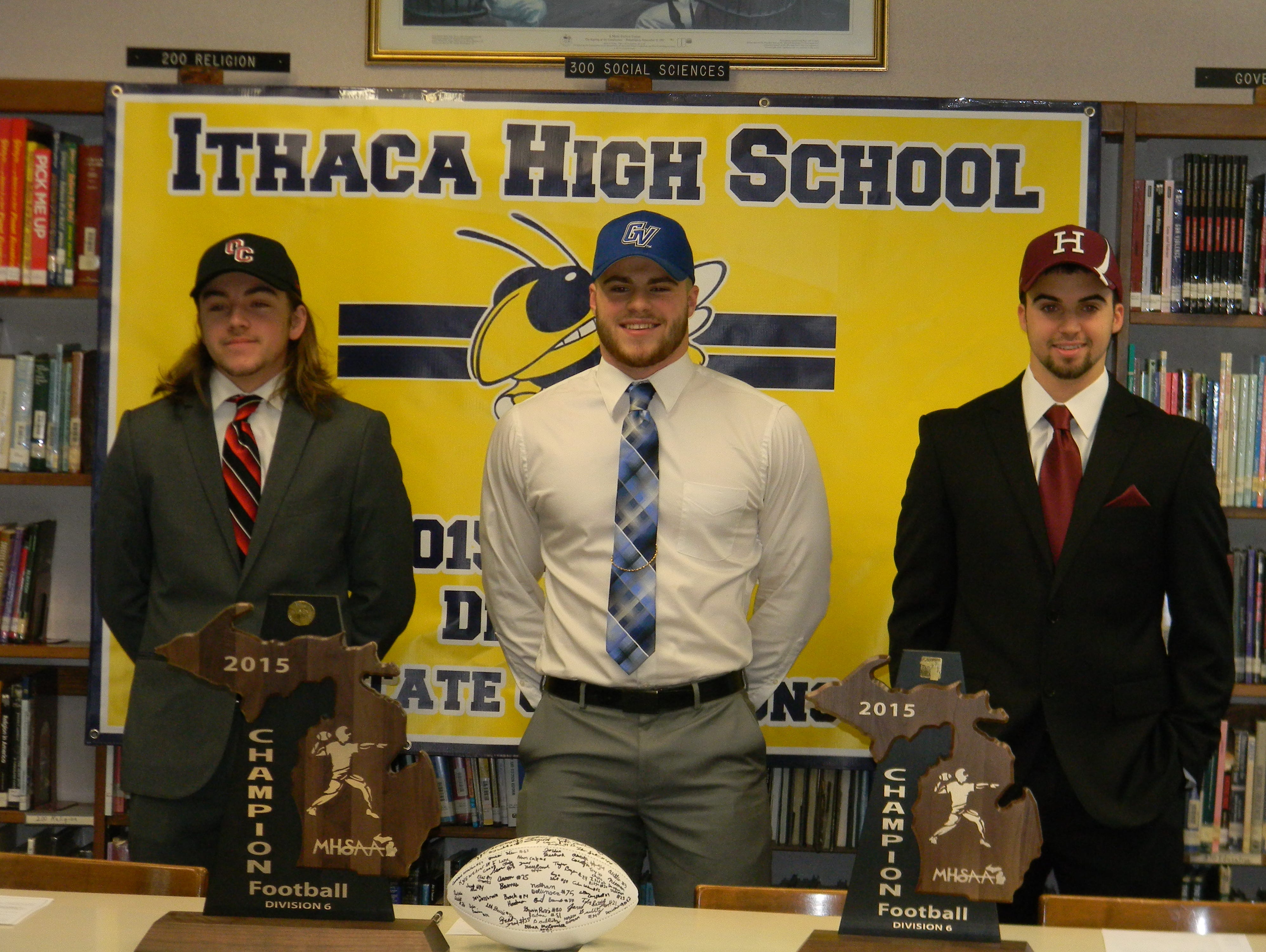Ithaca seniors Grant Gimmey, left, Jace Demenov, center, and Jake Smith pose for a picture after signing with their respective colleges Wednesday morning. Gimmey is headed to Olivet College, Demenov to Grand Valley and Smith to Harvard.