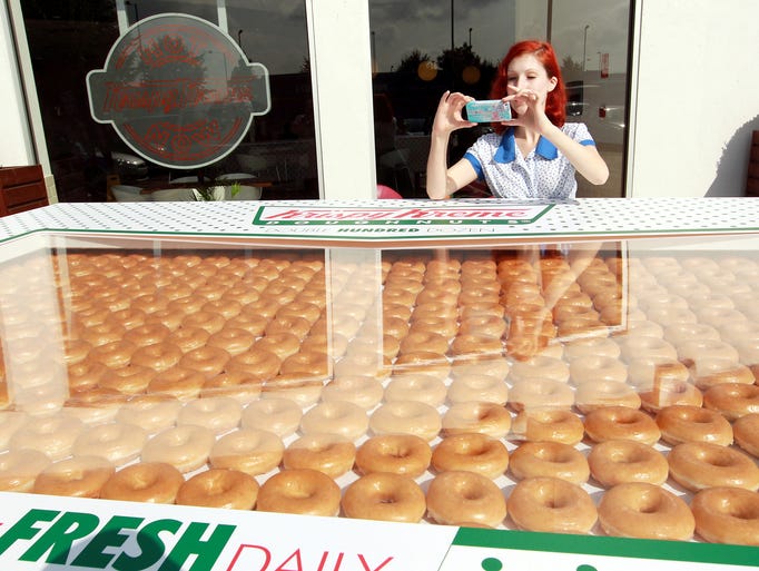 A woman snaps a photograph of Krispy Kreme's giant box of 2,400 doughnuts on Sept. 22 in North London, England. The Double Hundred Dozen box of doughnuts was prepared by eight staff members at the Enfield Hotlight store.
