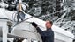 Bill Vickler sweeps snow off his Satellite,  in Spokane,