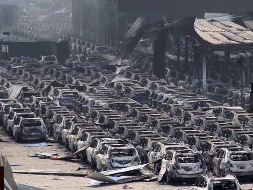 Damaged cars are seen at the site of a series of explosions