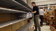 Lee Milam stocks empty shelves with bottled water at