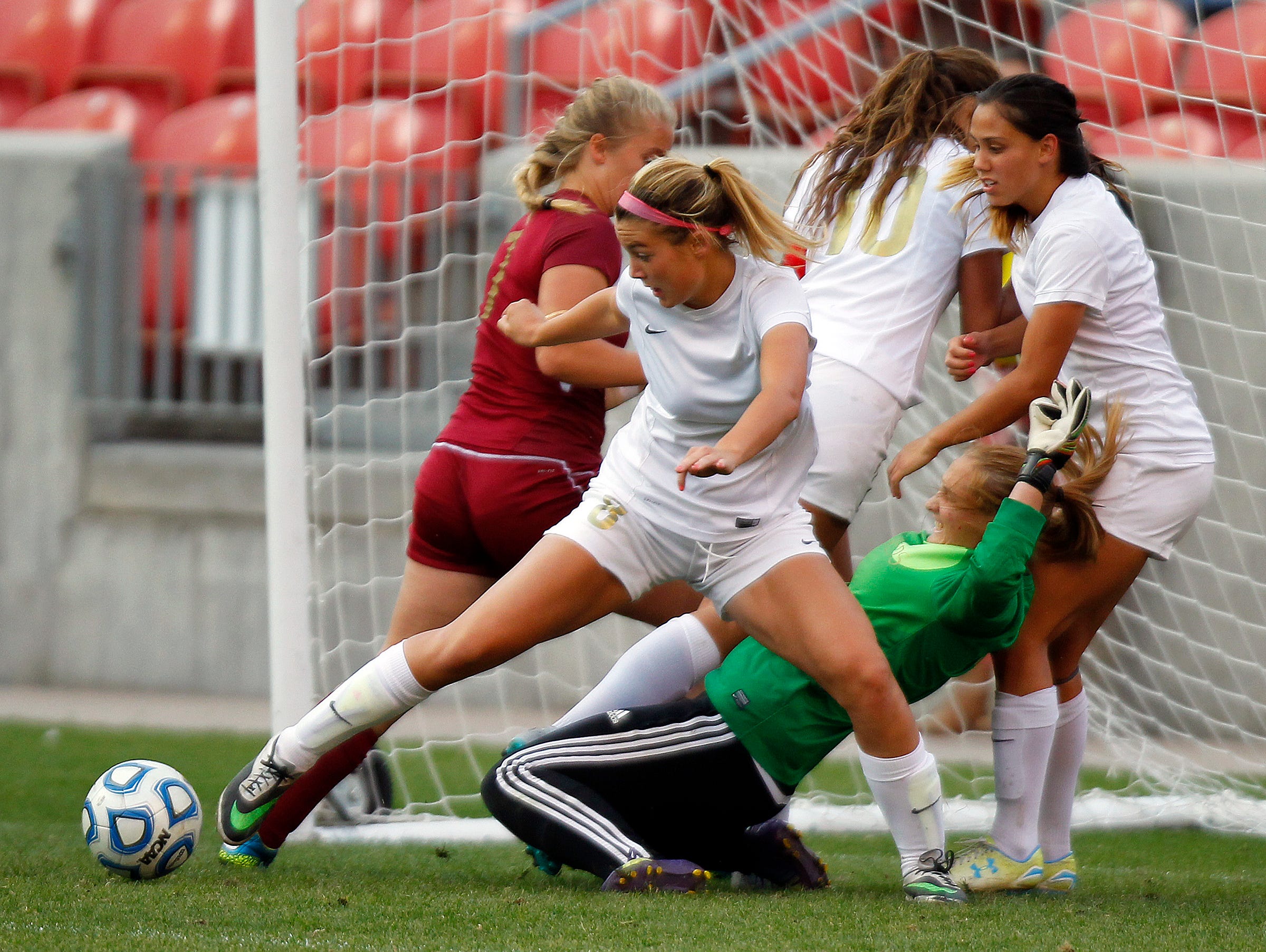 Logan and Cedar fight to control the ball in front of the Cedar goal in the 3A girls high school soccer championship at Rio Tinto Stadium on Saturday.