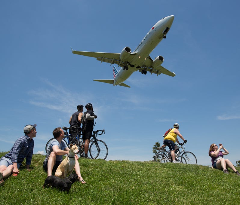 People watch planes at Gravelly Point Park, just north of the runway at Washington DC's Reagan National Airport on May 24, 2015.