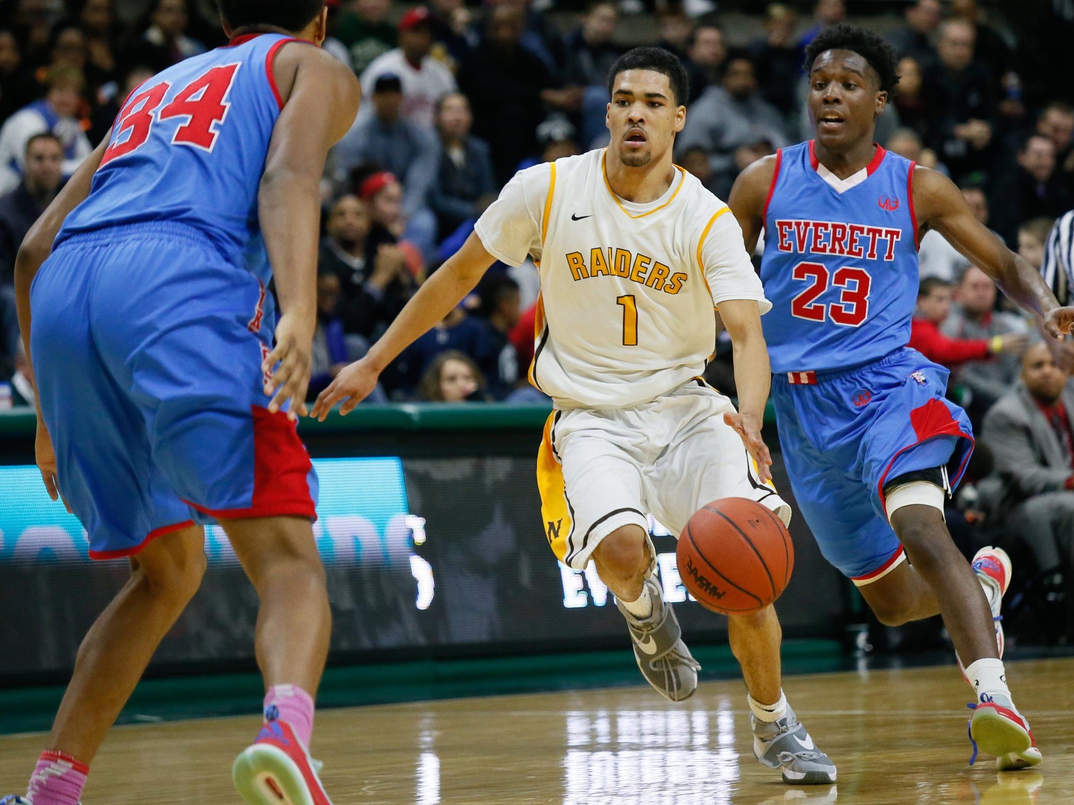 North Farmington's Billy Thomas has a fast break against Lansing Everett's Victor Edwards and Diego Robinson, during the MHSAA boys basketball Class A semifinals at the Breslin Center in East Lansing, Mich. on Friday, March 25, 2016.