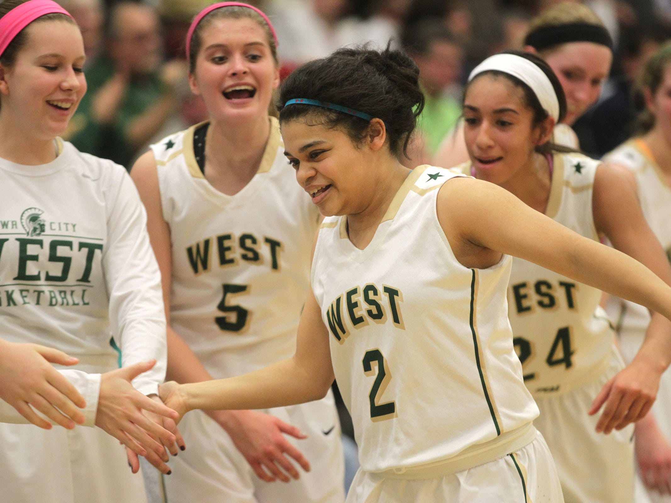West High senior Bella Lozano-Dobbs gets high-fives as she heads to the bench in the final minute of the Women of Troy's Class 5A regional final against Pleasant Valley on Tuesday, Feb. 24, 2015. West High won, 45-27, to advance to the state tournament. David Scrivner / Iowa City Press-Citizen