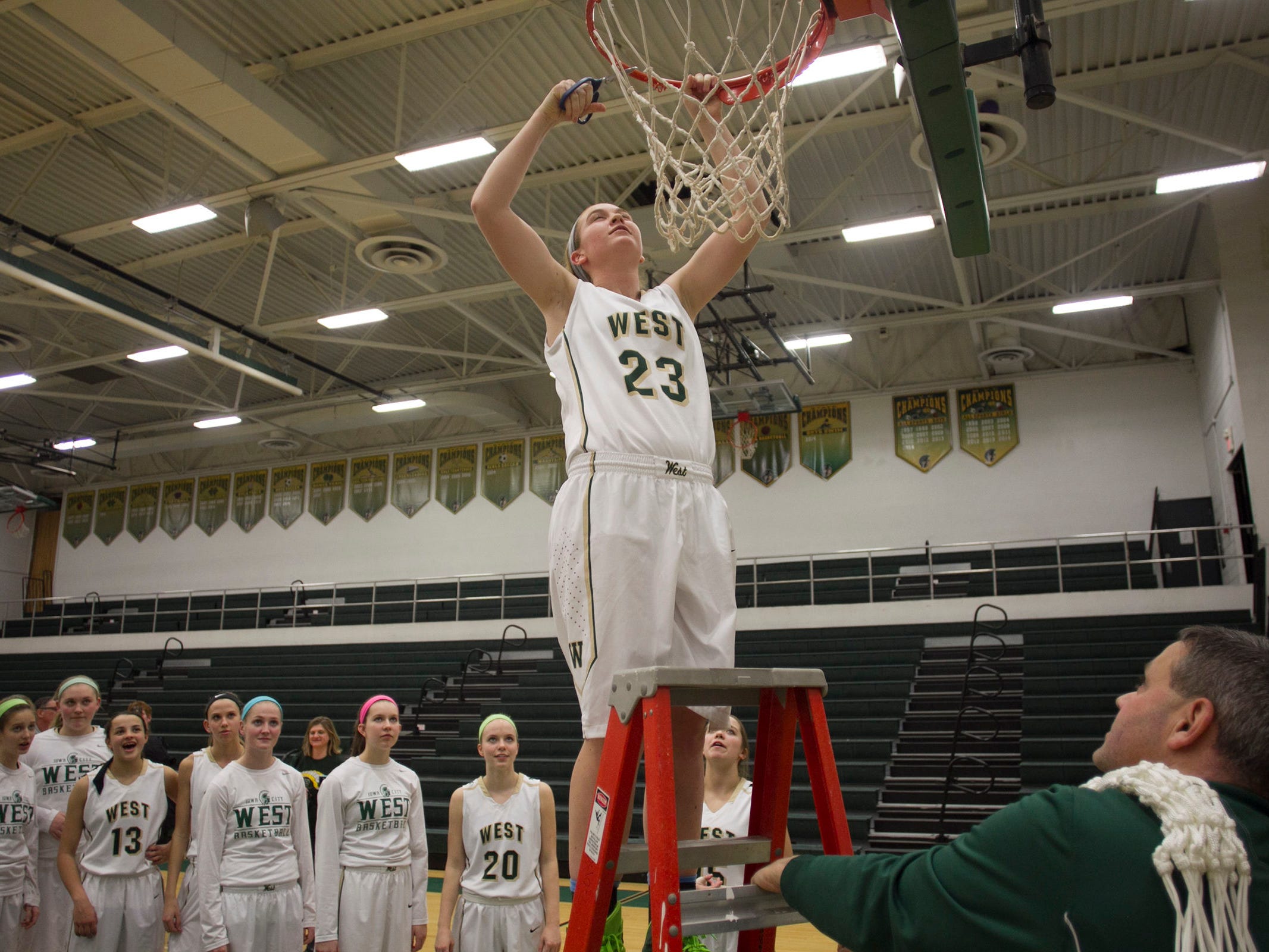West High's Jessie Harder helps cut down the net following the Women of Troy's Class 5A regional final against Pleasant Valley on Tuesday, Feb. 24, 2015. West High won, 45-27, to advance to the state tournament. David Scrivner / Iowa City Press-Citizen