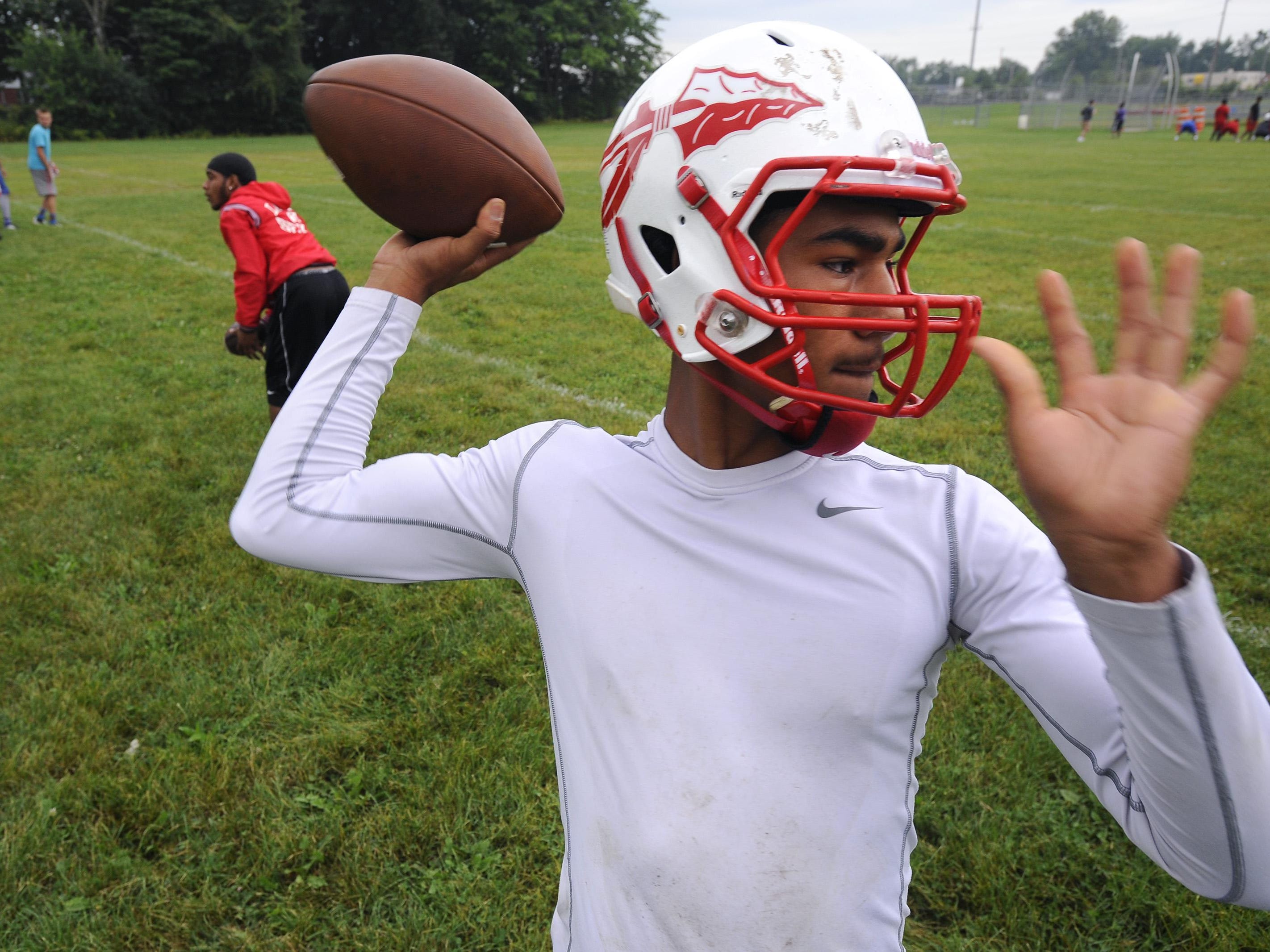 Sexton quarterback Michael Lynn III throws to receivers at the opening of football practice Monday morning.