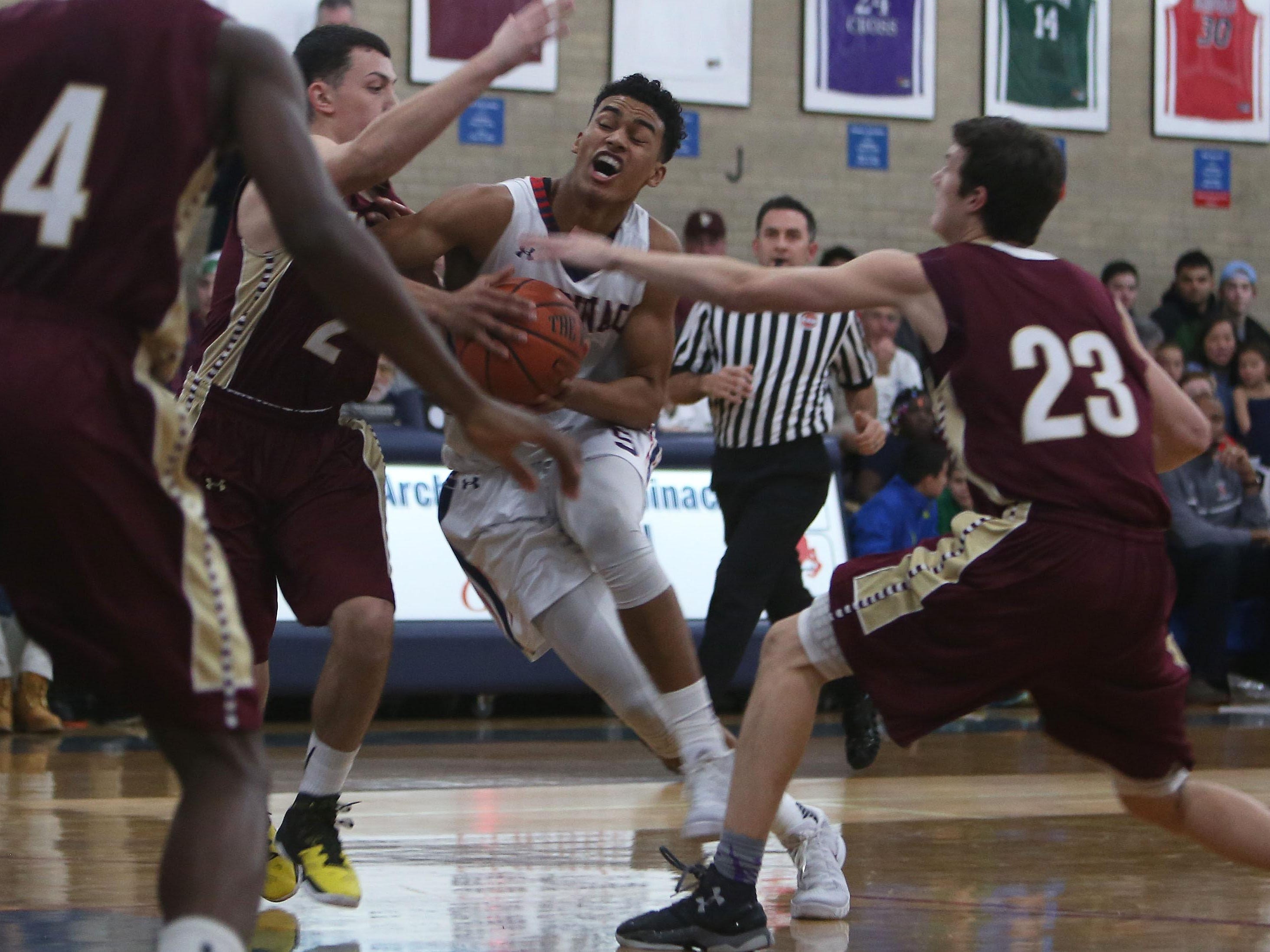 Stepinac's Jordan Tucker (5) drives to the basket while covered by Iona's Jon Brennen (2) and Patrick Flemming (23) during boys basketball action at Archbishop Stepinac High School in White Plains Jan. 8, 2016.