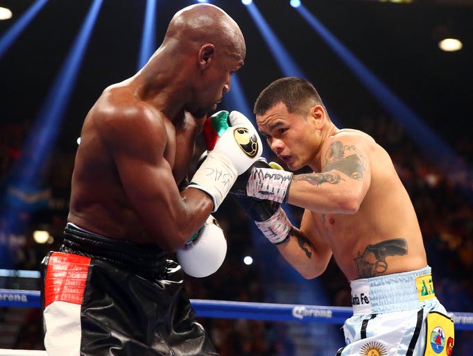 Marcos Maidana defends against Floyd Mayweather Jr. during their fight at MGM Grand.