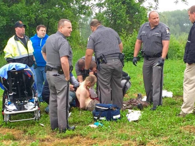 Police officers surround David Sweat after he was shot