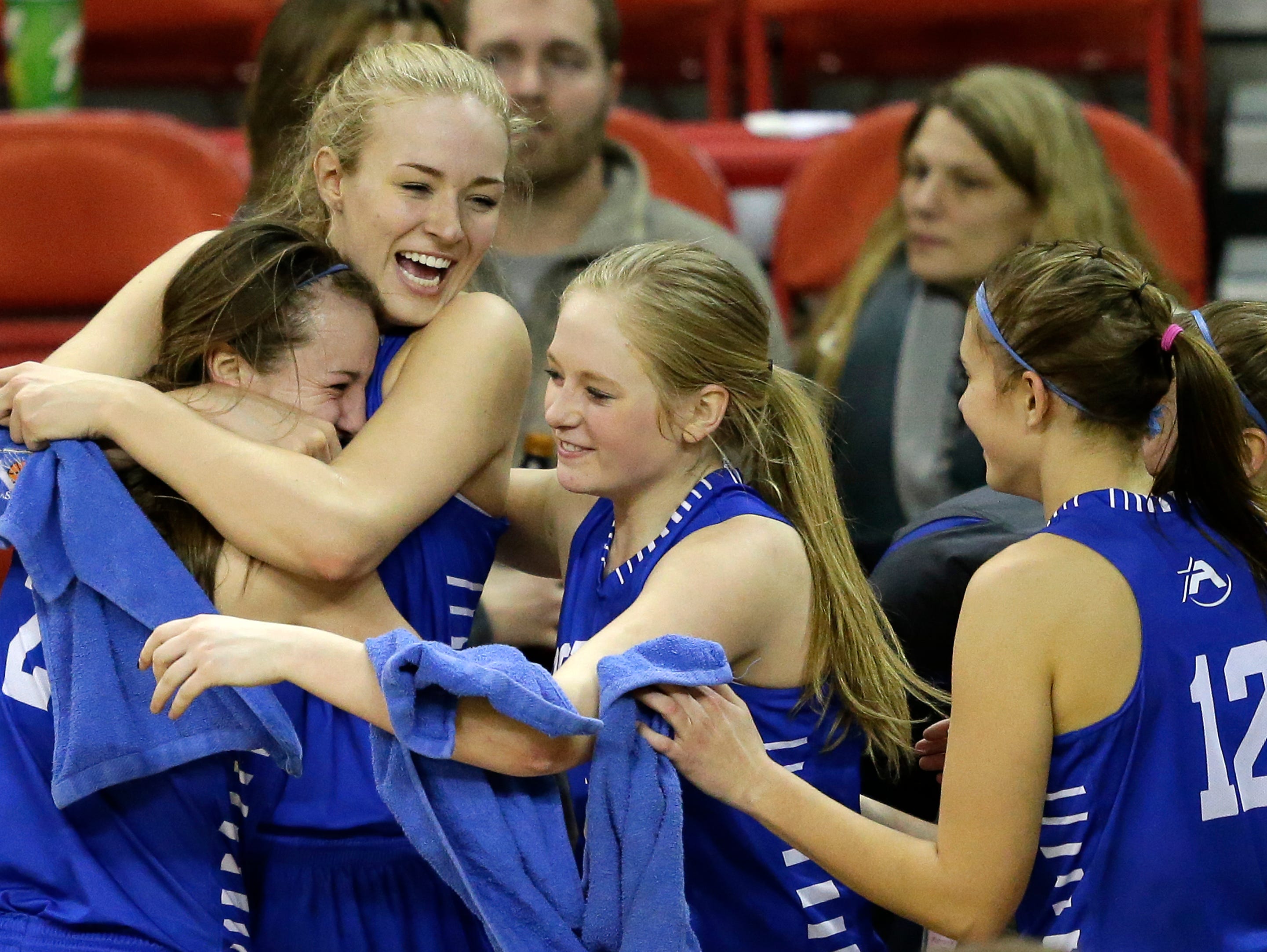 Assumption players celebrate their victory against South Shore during their WIAA Division 5 semifinal basketball game at the Resch Center in Ashwaubenon.