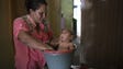 Solange Ferreira bathes her son Jose Wesley in a bucket