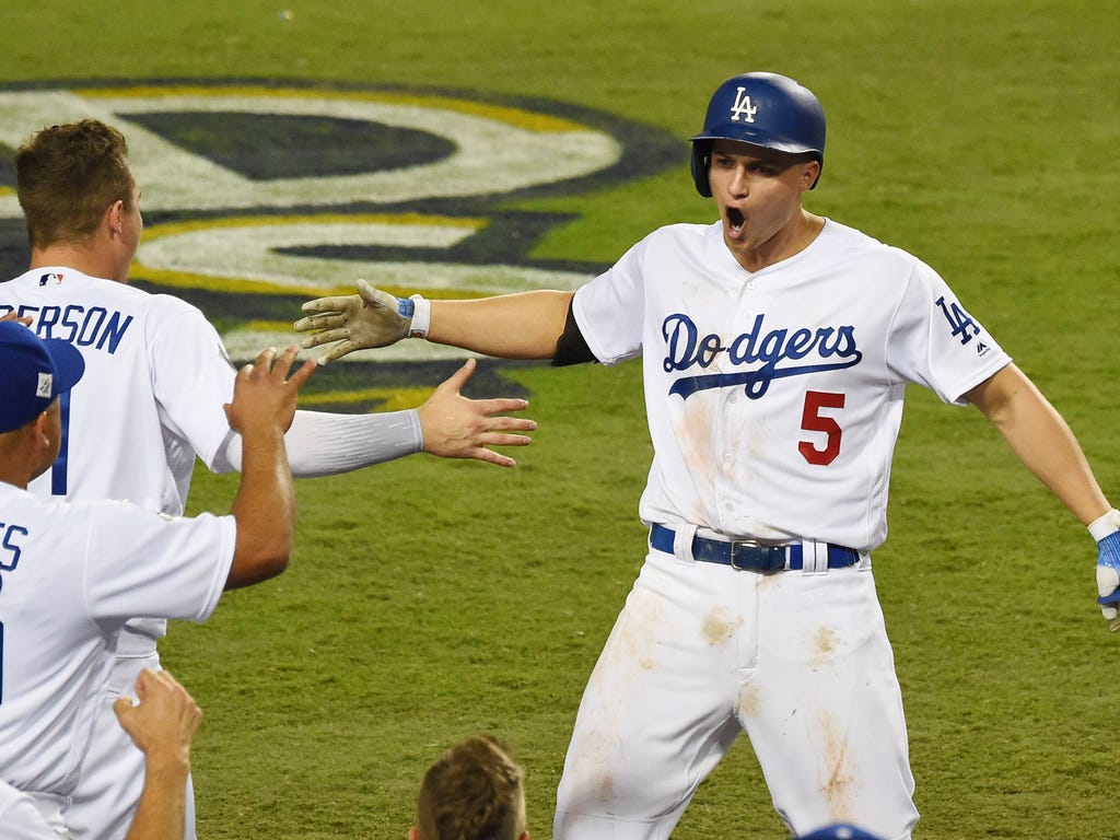 Los Angeles Dodgers shortstop Corey Seager celebrates with outfielder Joc Pederson and manager Dave Roberts after hitting a two-run home run against the Houston Astros in the sixth inning of Game 2 of the World Series at Dodger Stadium.