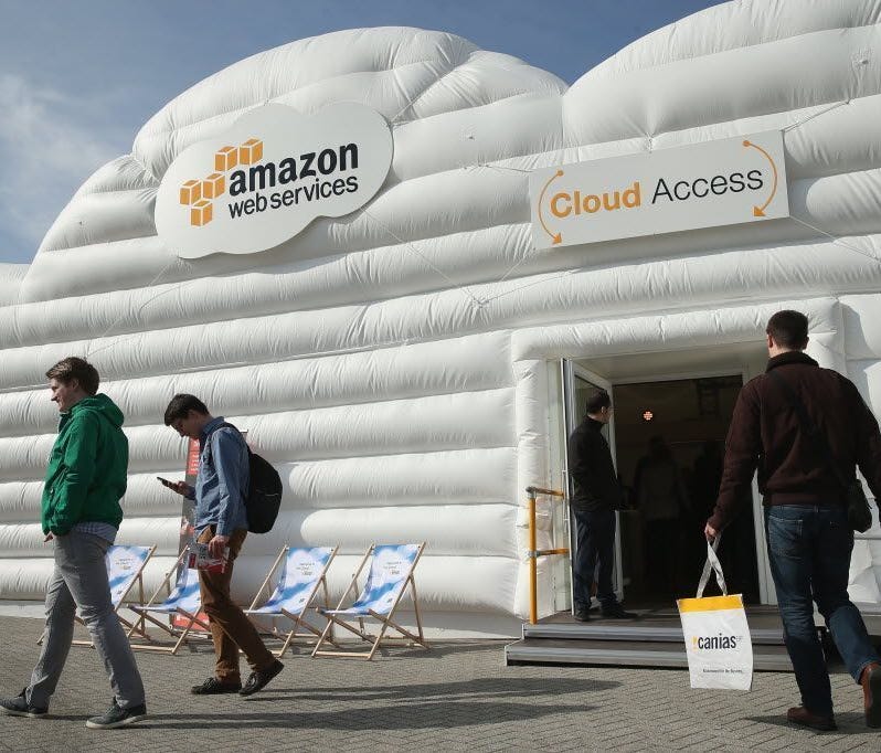 Visitors arrive at the cloud pavilion of Amazon Web Services at the 2016 CeBIT digital technology trade fair on March 14, 2016.