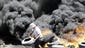 A Palestinian burns tires during clashes with Israeli security forces after a protest in the village of Kfar Qaddum, near the northern city of Nablus in the West Bank on July 11.