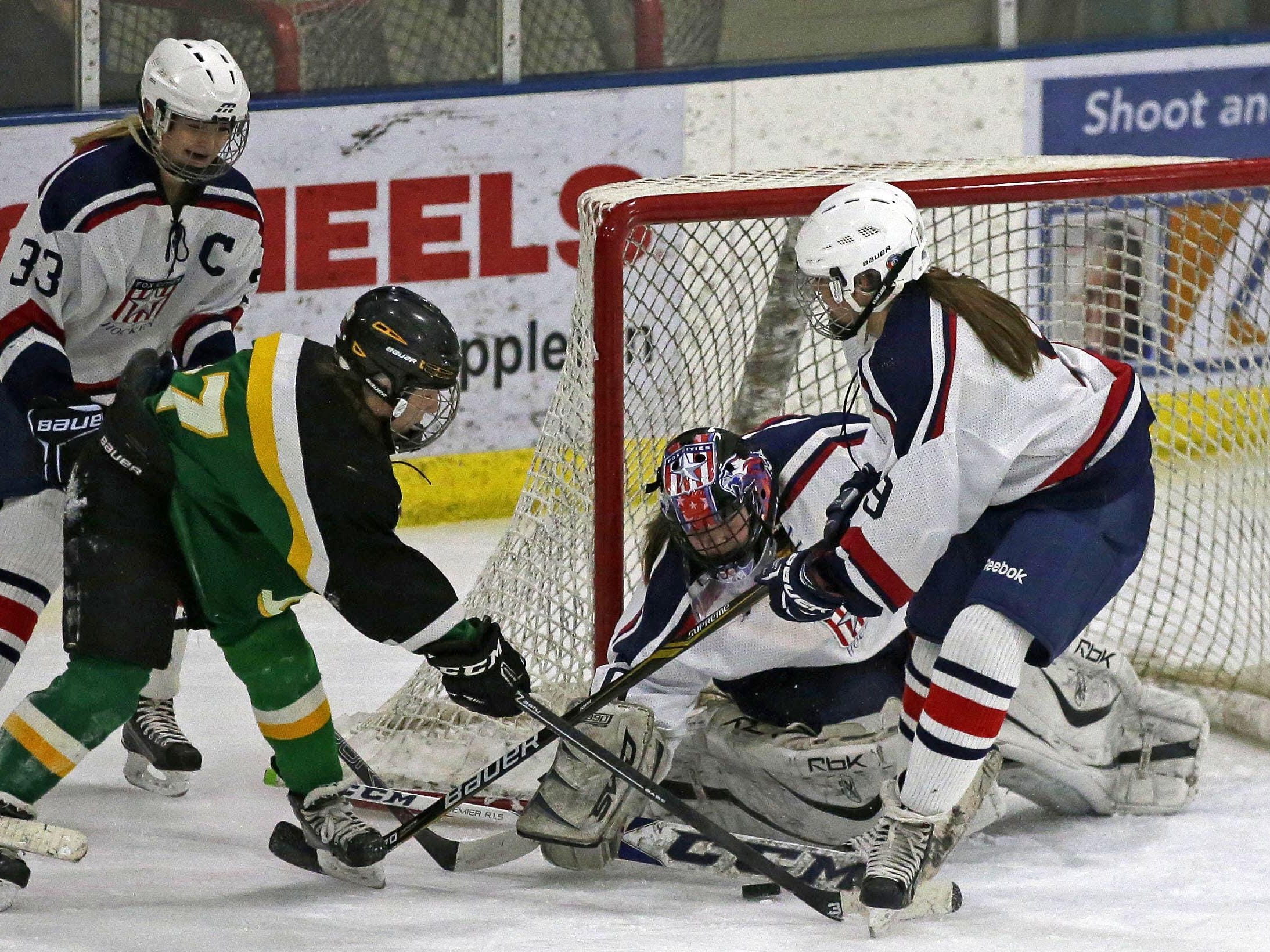 Ky Jansen (33), Lauren Fine (9) and goalie Annaliese Mauel of the Fox Cities Stars protect the goal from Alyssa Heim of the Beaver Dam Golden Beavers on Thursday at Tri-County Ice Arena.