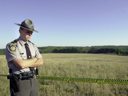 A Pennsylvania State Trooper stands guard at the crash