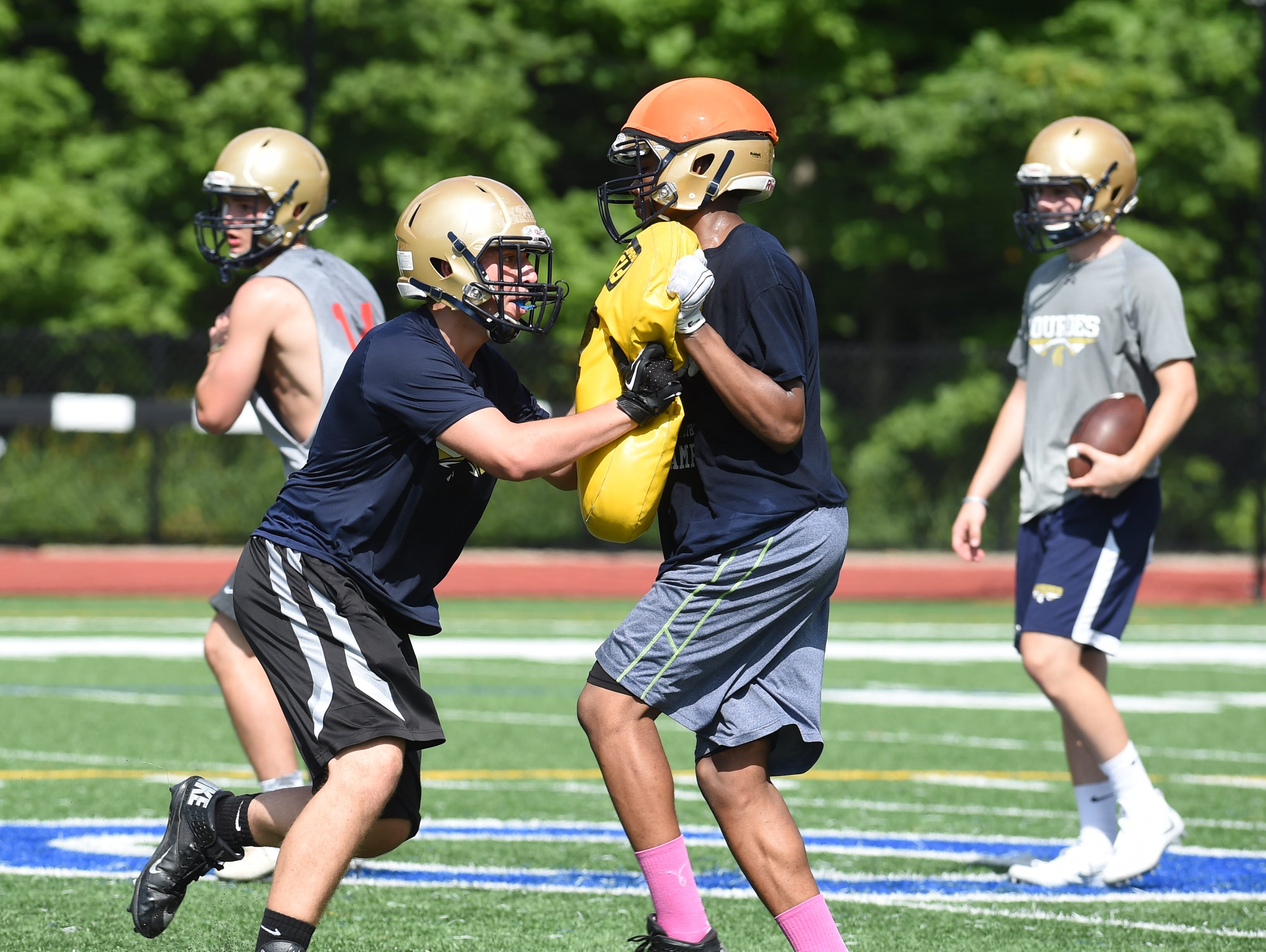 Juniors Sean McDowell, left, and Malik Wright, right, at Our Lady of Lourdes High School grapple during preseason football practice.